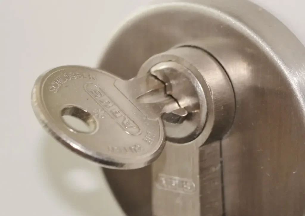 Key inserted in a door lock cylinder – how to choose a trustworthy locksmith in Runcorn before a lock is drilled or replaced, Locksmith Runcorn