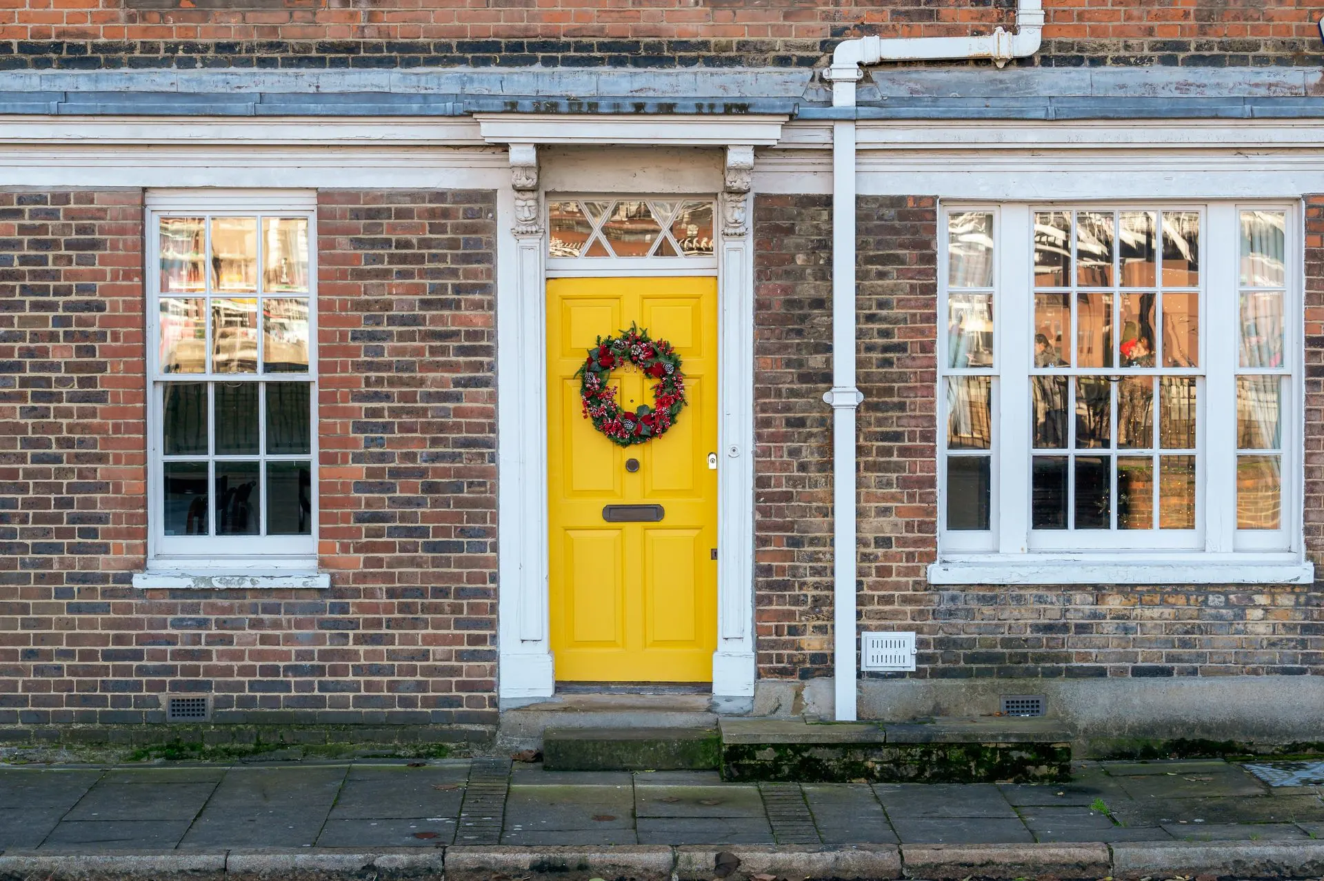 Yellow front door on a red-brick Victorian house